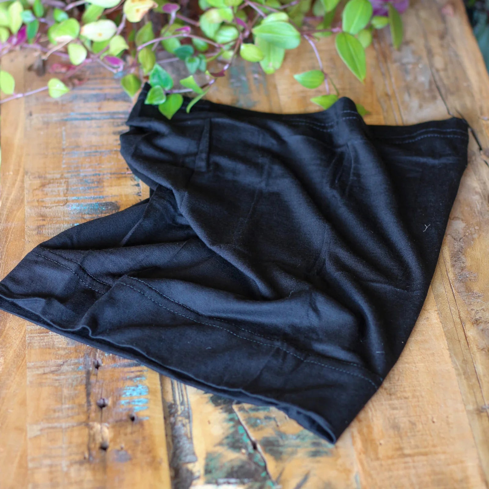 Black coloured Bamboo Dreadlock Tube Headband on a table.