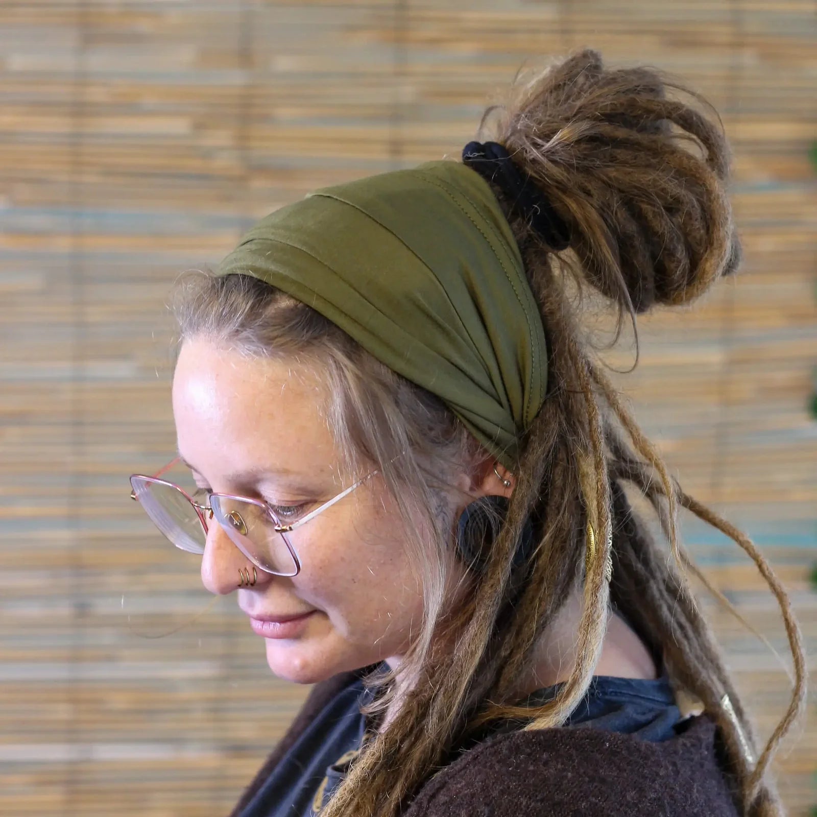 Lady wearing a green coloured Bamboo Dreadlock Tube Headband.