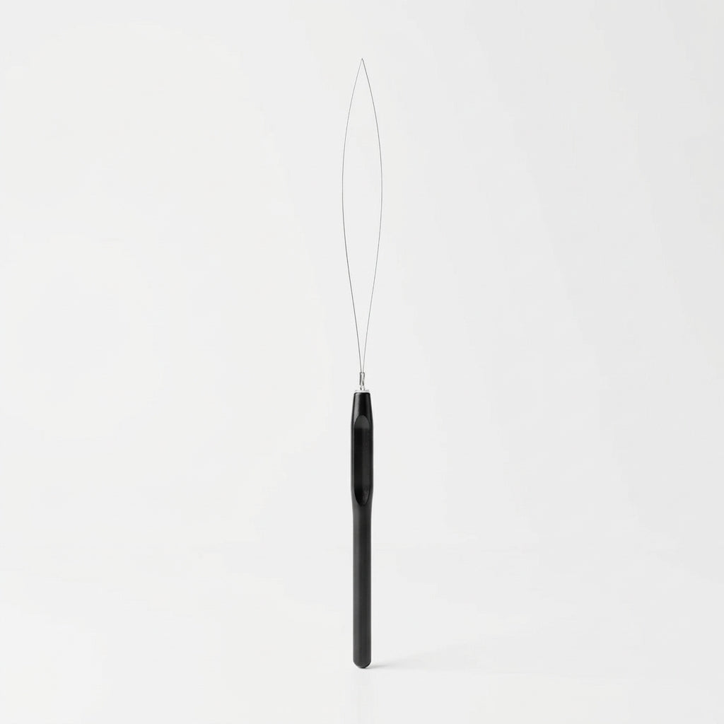 Black bead threader on a white background