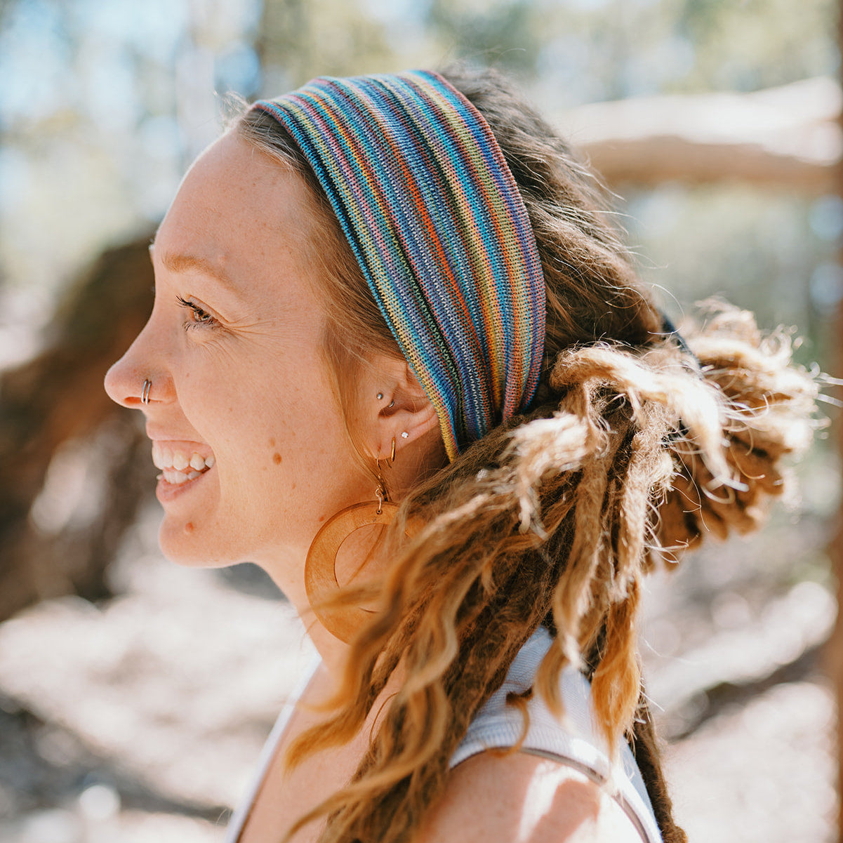 Woman with a colorful headband and braided hair in an outdoor setting