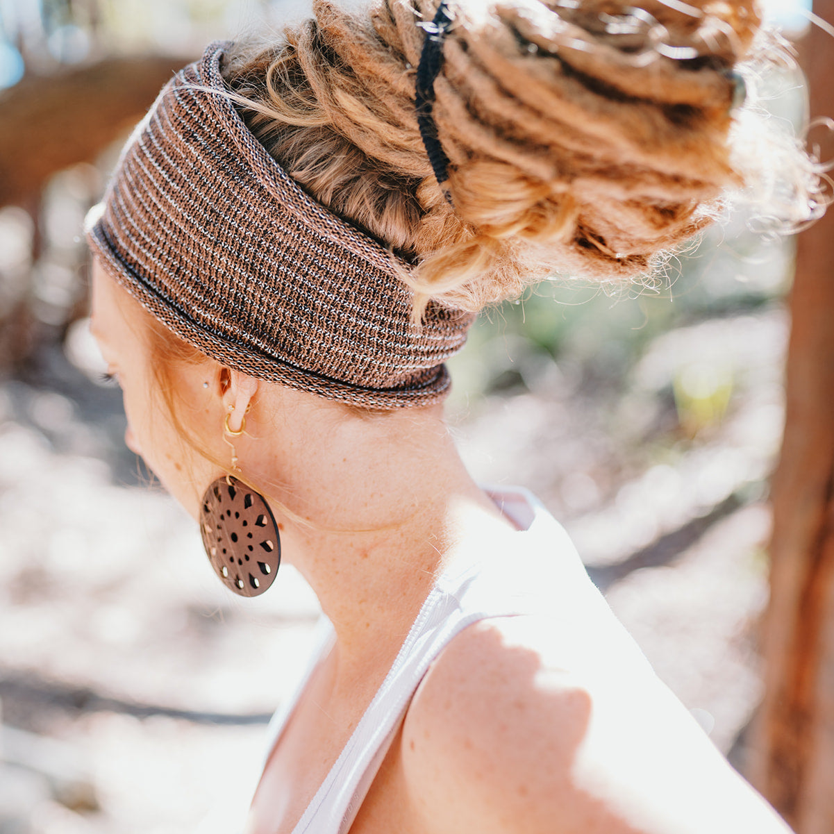 Person with braided hair wearing a headband in a natural setting