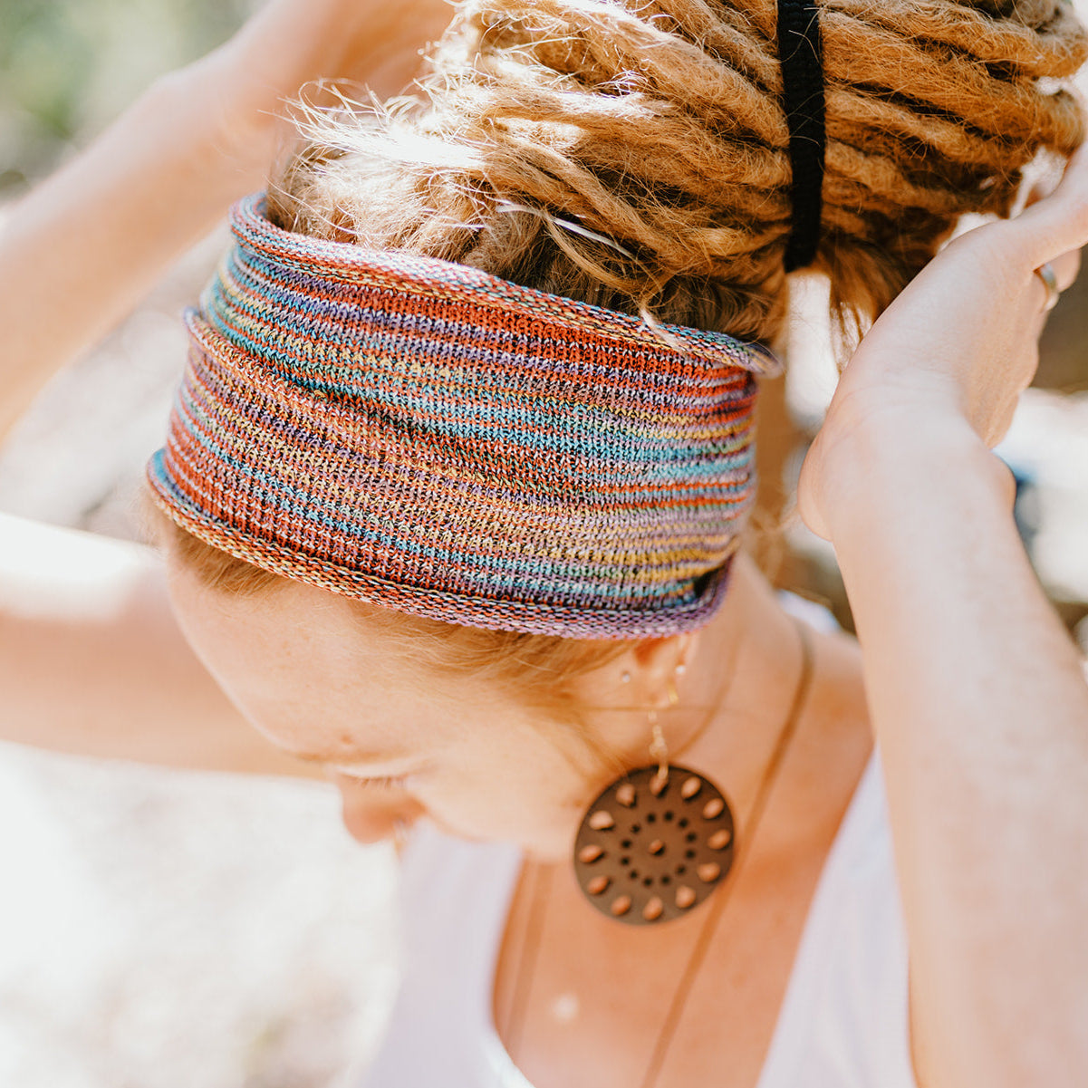 Person wearing a colorful headband with a blurred natural background