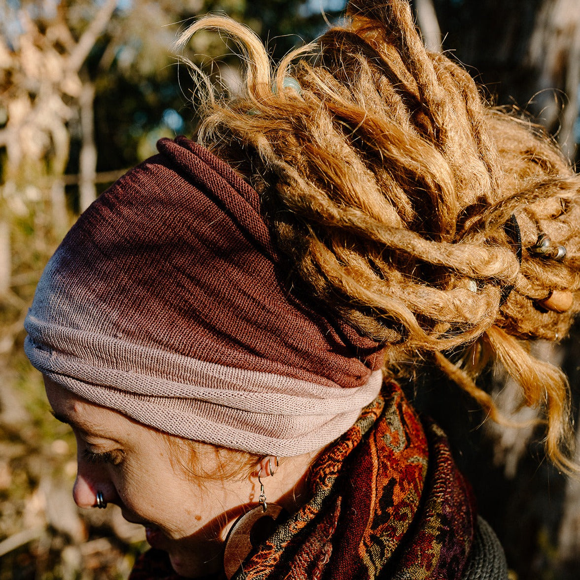 Lady with dreads wearing a brown and white cotton double loop hair wrap