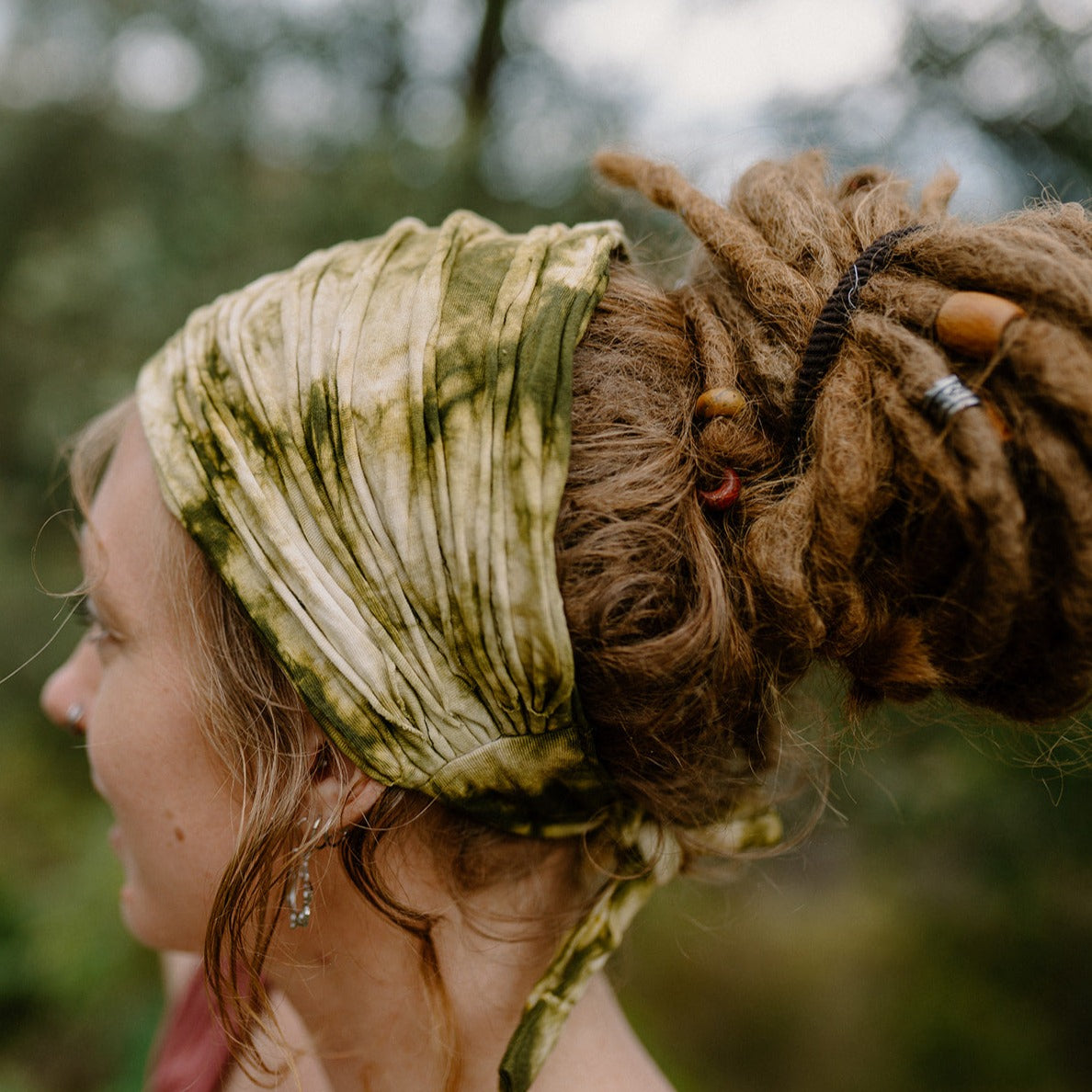 Lady wearing a green cotton tie-up headband in a natural setting