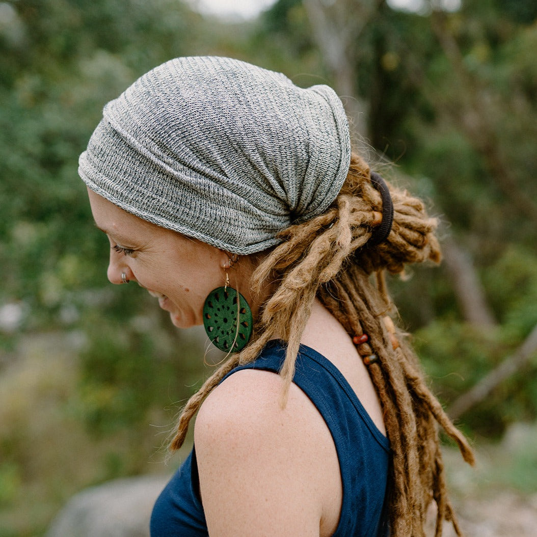 A person wearing a beige wide cotton headband.