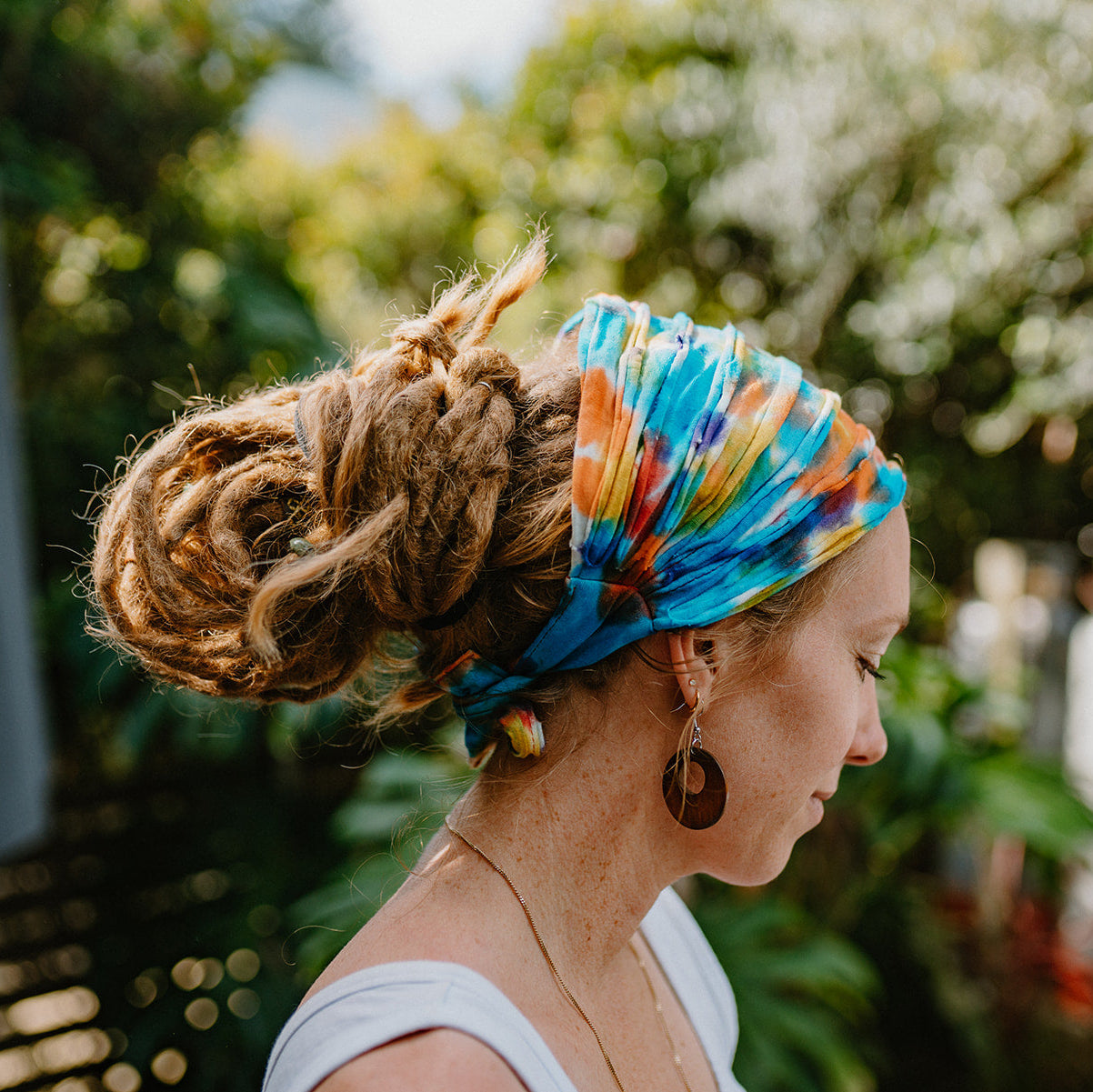 Lady with a rainbow cotton tie up hair tie in a natural setting.