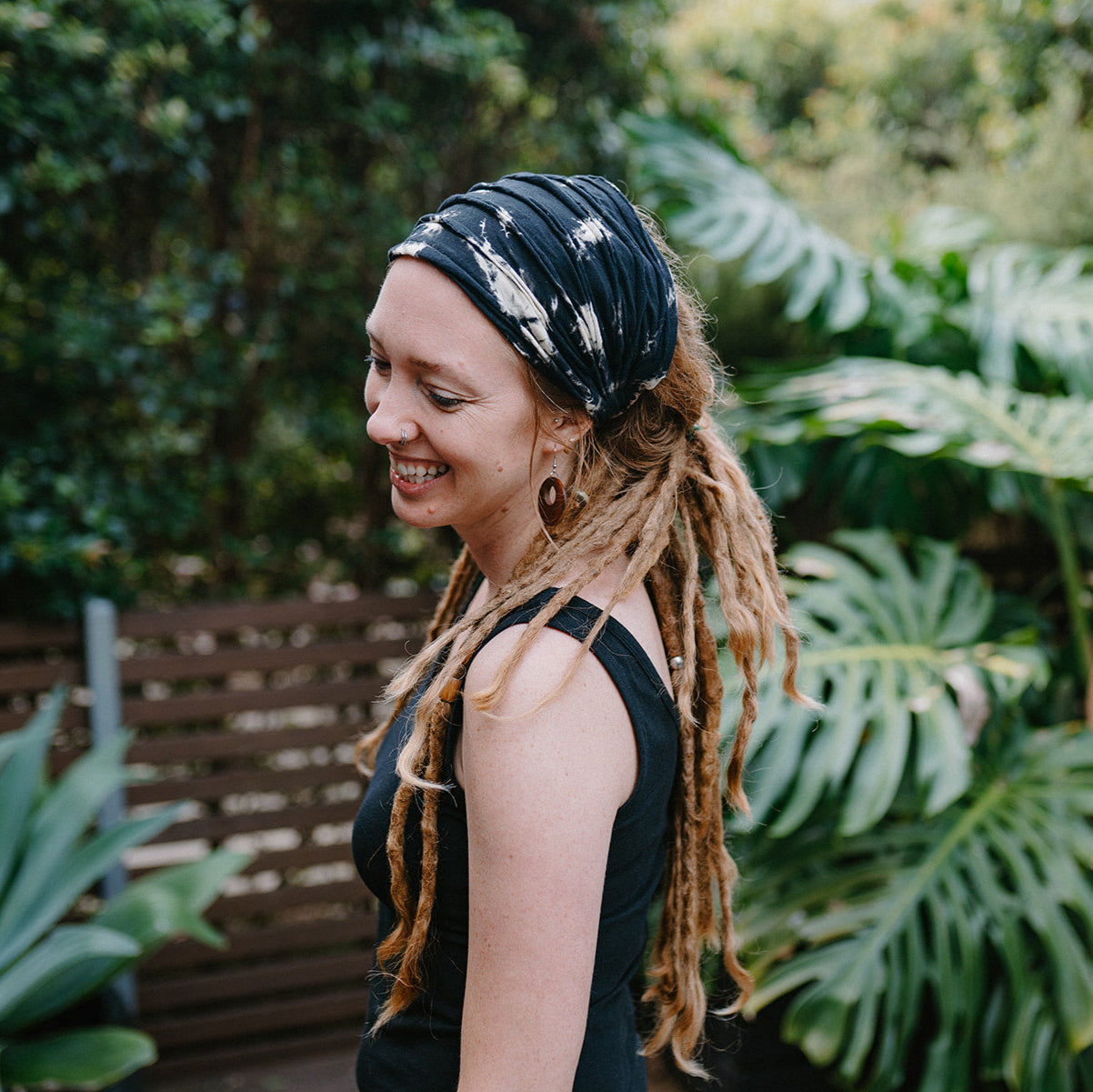 Lady wearing a black cotton tie up headband in a natural environment.
