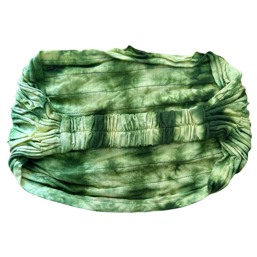 Green tie-dye headband with elastic back on a white background