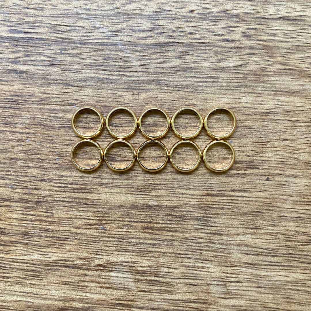 18K Gold Plated Stainless Steel Rings, set of 10 in 8mm hole size on a wooden background - Mountain Dreads