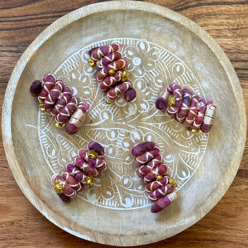 Mini sized Pink, purple, and white wire dreadlock tie, spiralock, with gold shapes.