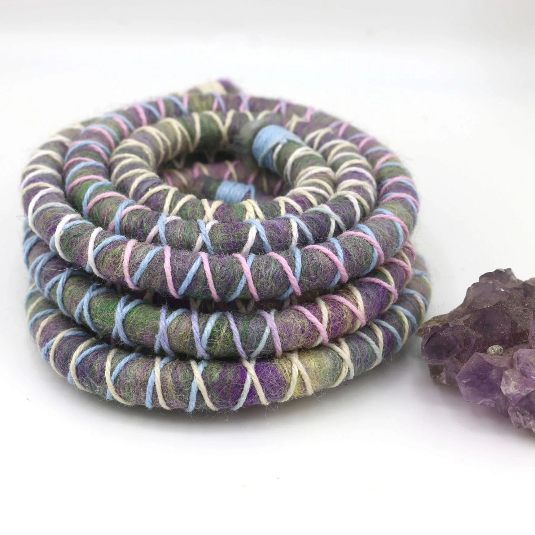 Purple, pink and blue dreadlock spiralock hair tie on a white background