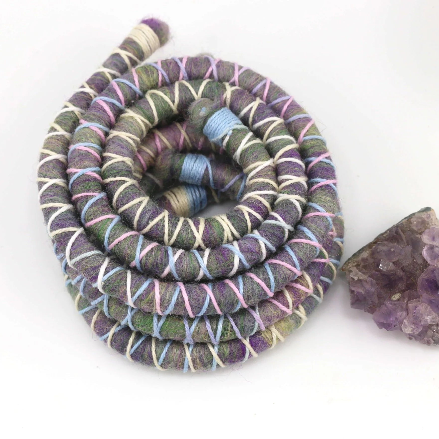 Purple, pink and blue dreadlock spiralock hair tie on a white background