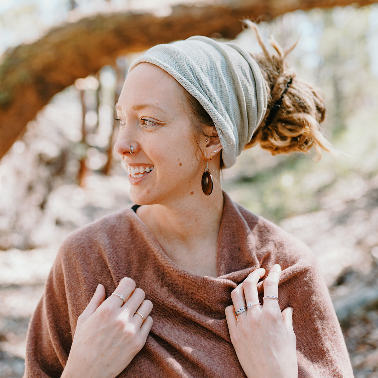 Woman wearing a headscarf and brown shawl in a natural setting