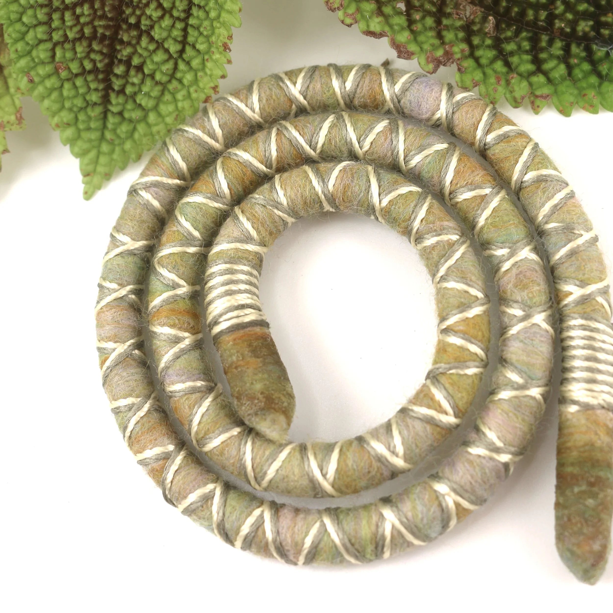 Yellow, grey and green dreadlock spiralock hair tie on a white background