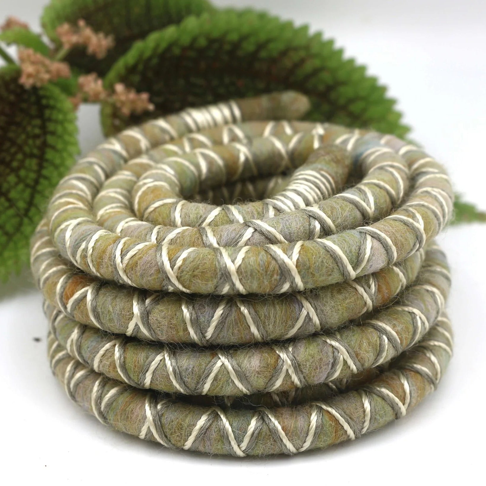 Yellow, grey and white dreadlock spiralock hair tie on a white background