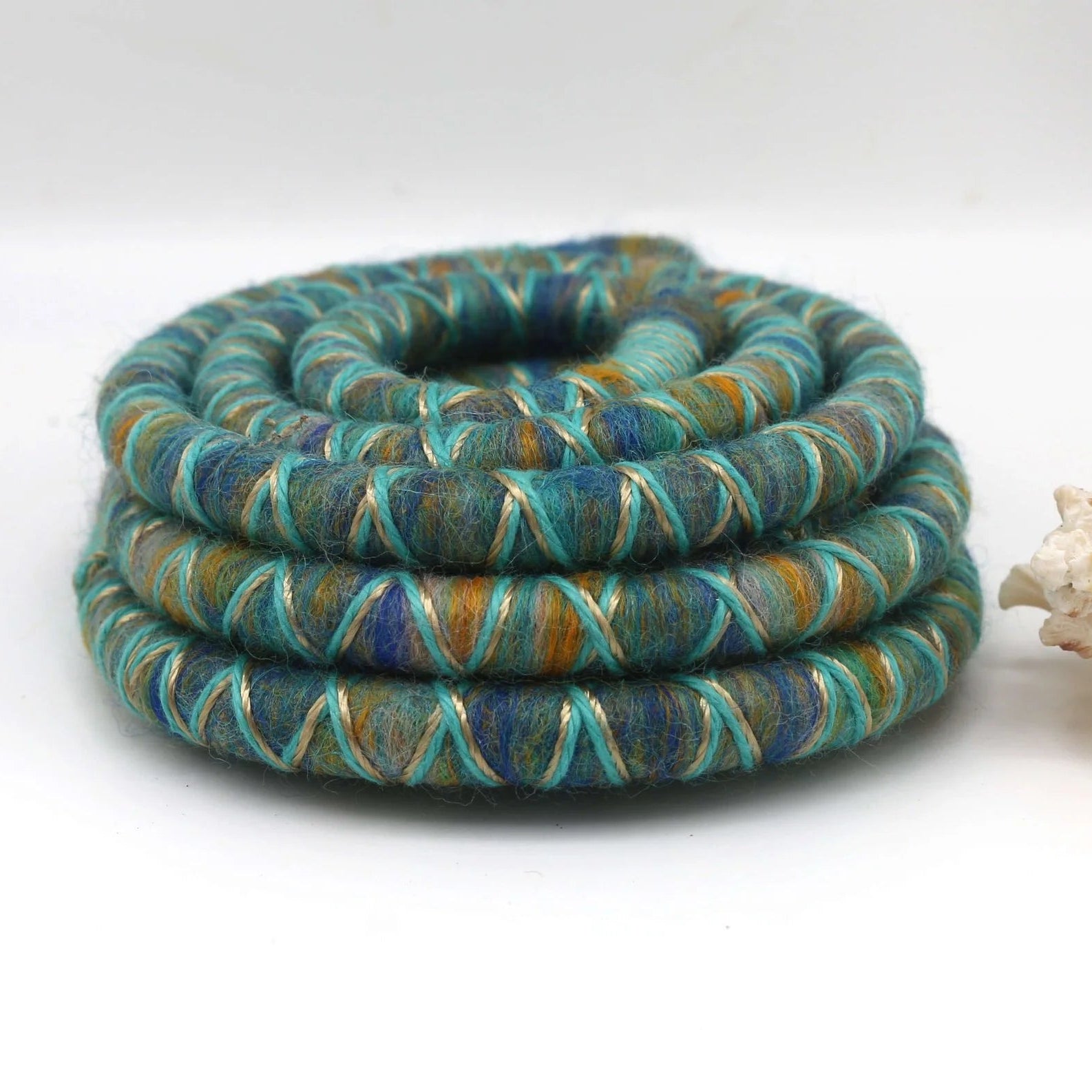 Green, yellow and blue dreadlock spiralock hair tie on a white background