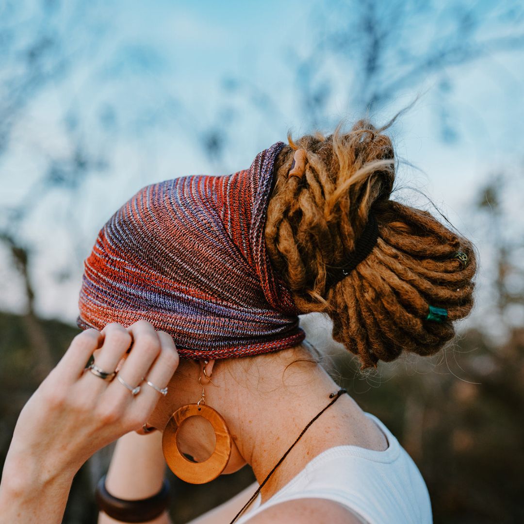 A person wearing a Pink Red and Brown wide cotton headband and a dread bun.