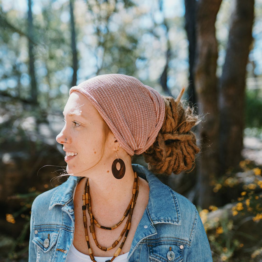 A person wearing a pink wide cotton headband.