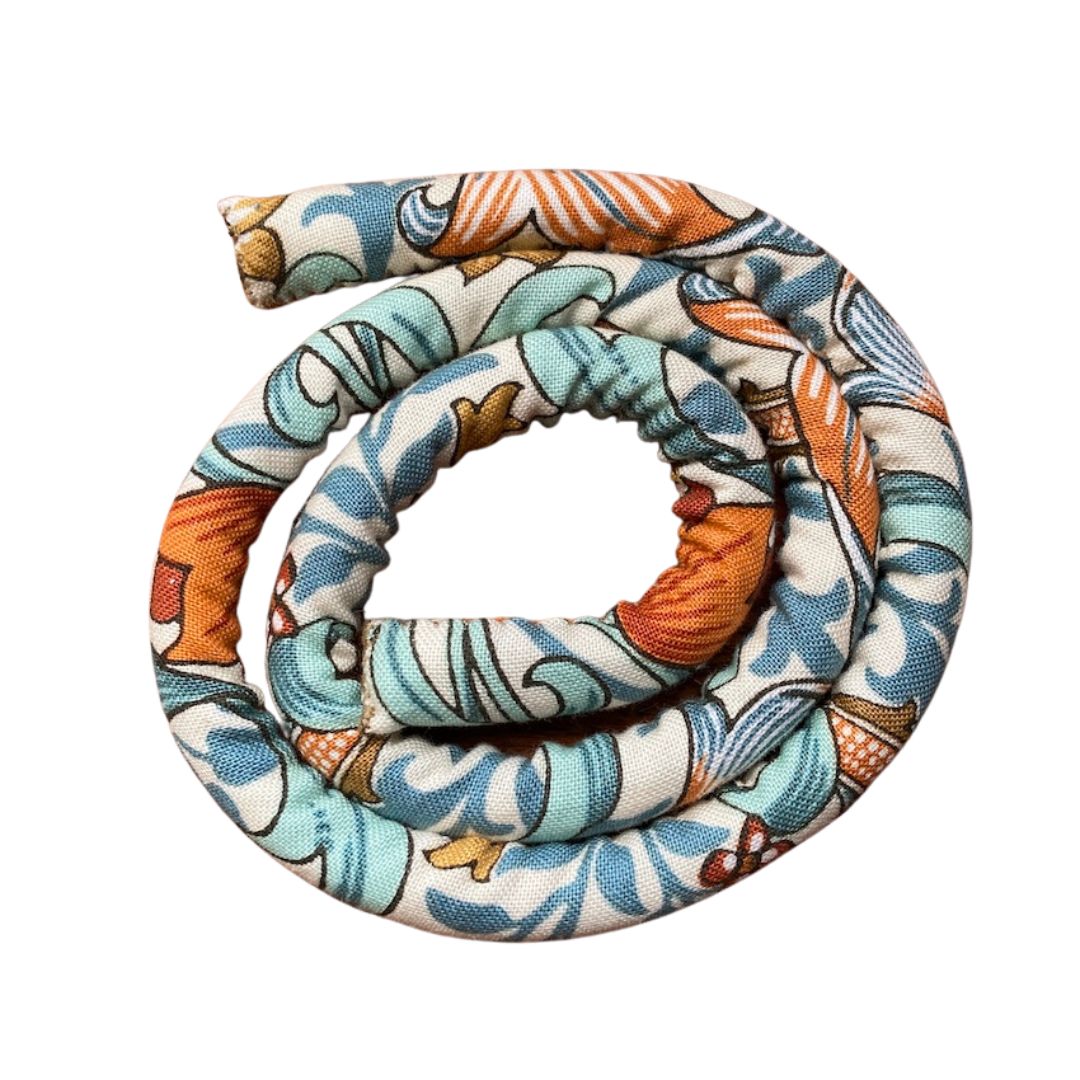 A spiral-shaped dreadlock tie, a spiralock, with a blue and white pattern, placed on a white surface.