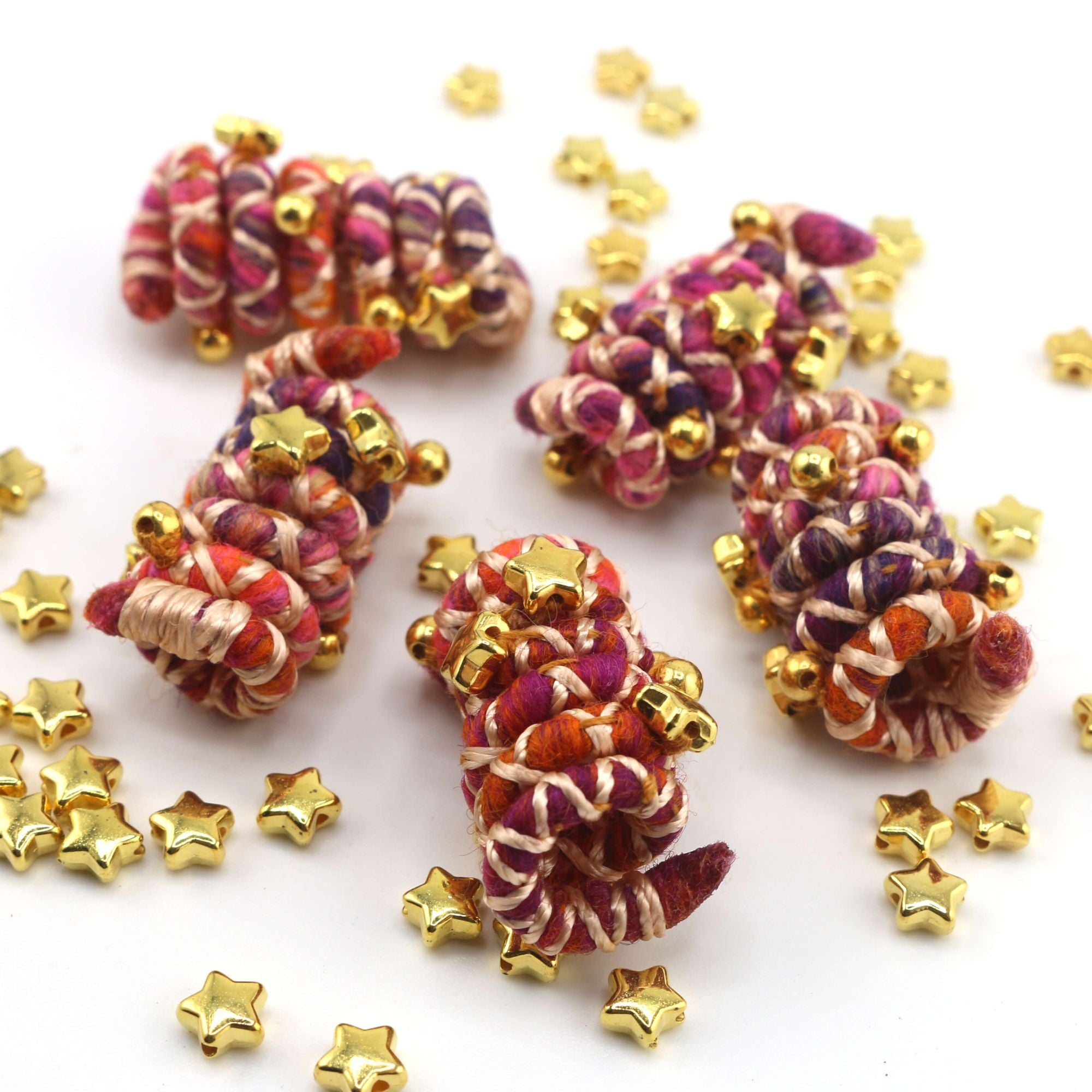 Mini sized Pink, orange, and white wire dreadlock tie, spiralock, with gold shapes. 
