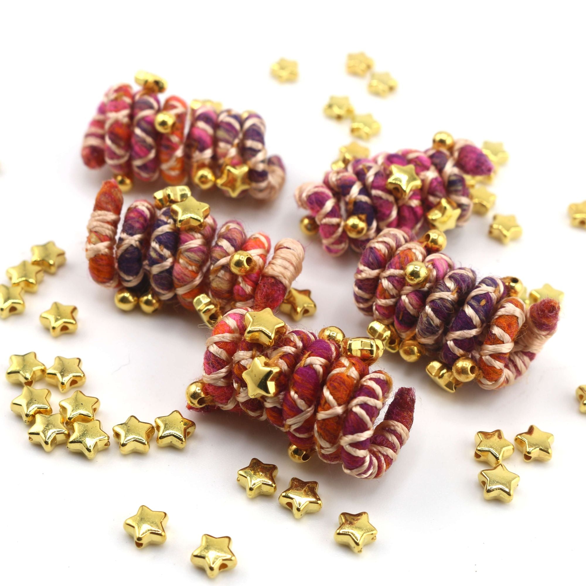 Mini sized Pink, orange, and white wire dreadlock tie, spiralock, with gold shapes. 