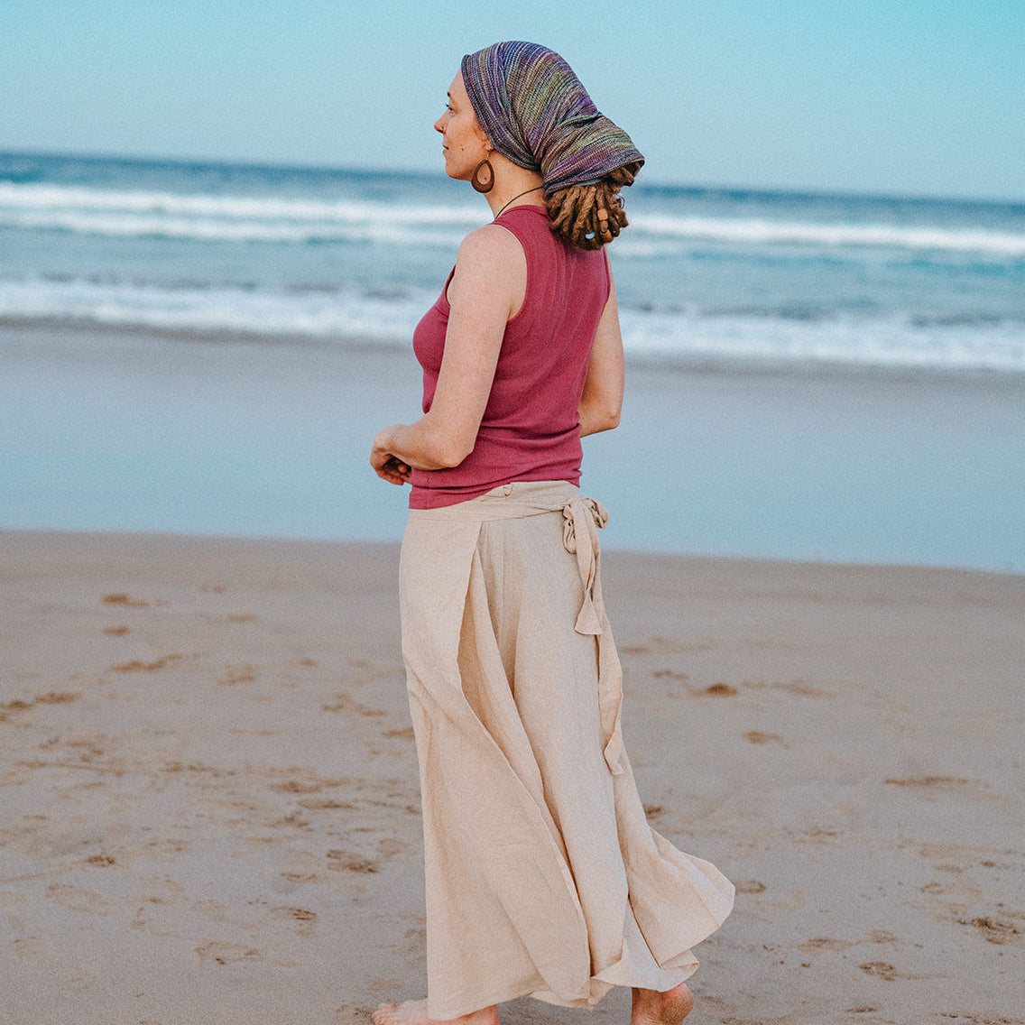 Woman walking on a beach with ocean waves in the background