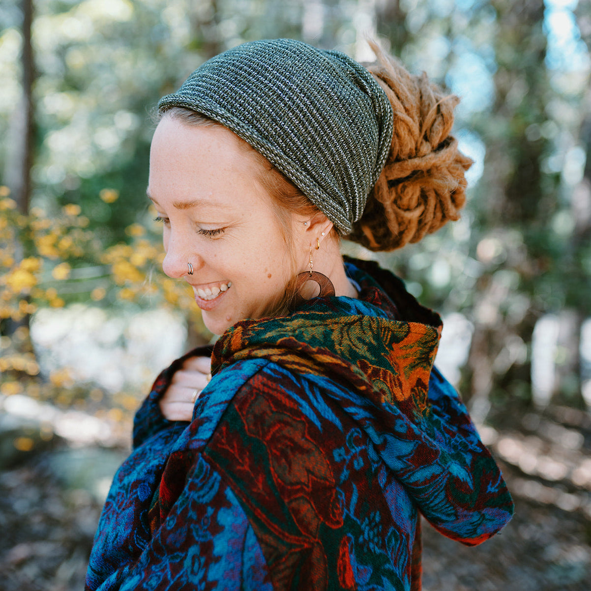 Woman with a colorful scarf and knitted hat in a forest setting