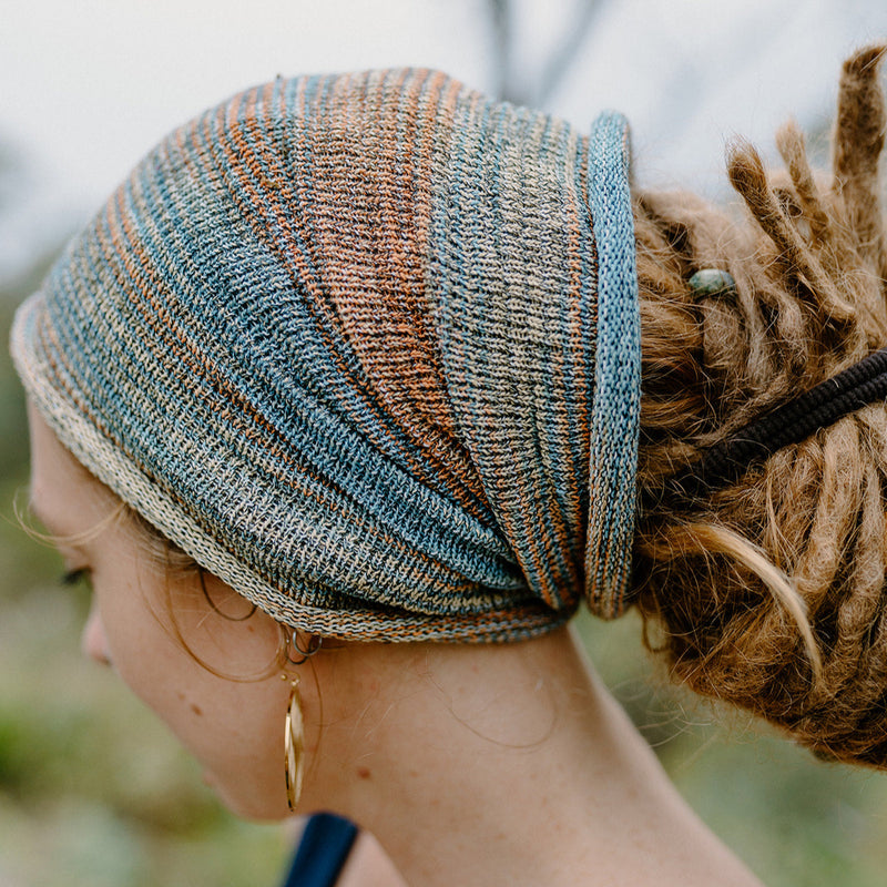 Person wearing a knitted headband with a blurred natural background
