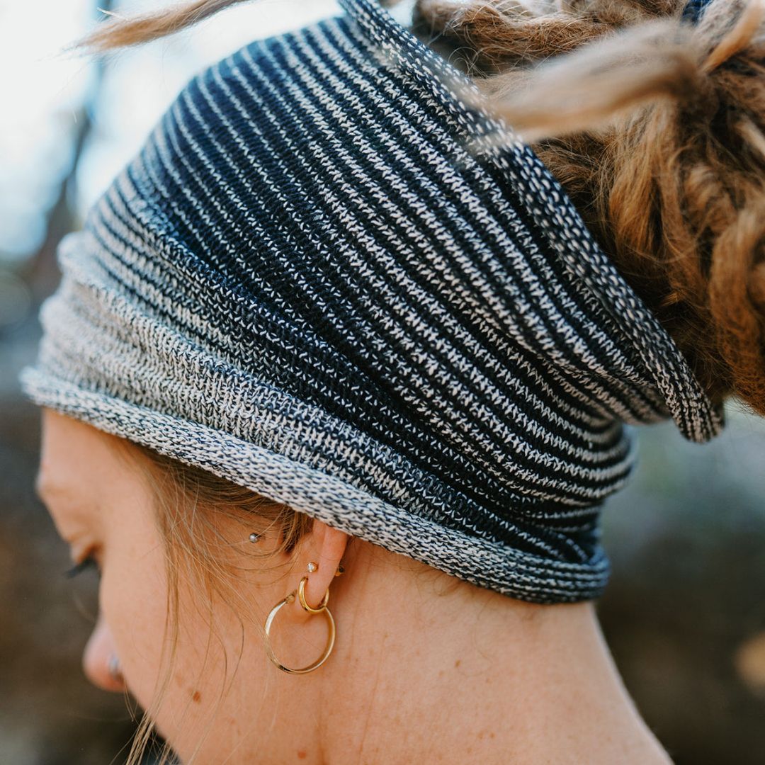 A person wearing a black and white wide cotton headband.